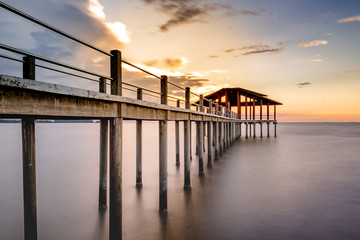 Fototapeta na wymiar Long exposure of a jetty leading to coast during sunset.