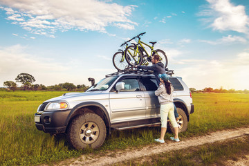 Couple taking off their bicycles from roof rack