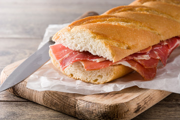 Spanish serrano ham sandwich on wooden table
