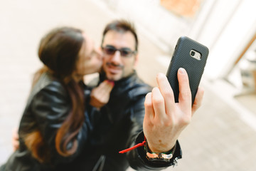 Couple in love doing a self-portrait selfie with the mobile phone.