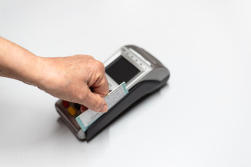 Woman's hand passing credit card by a dataphone, card reader to charge in time of sales.