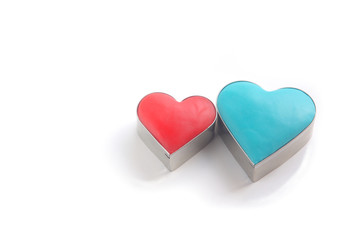 横長の白バックに置かれた抜き型と粘土で作った赤と青のハート