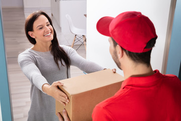 Delivery Man Giving Box To Young Woman