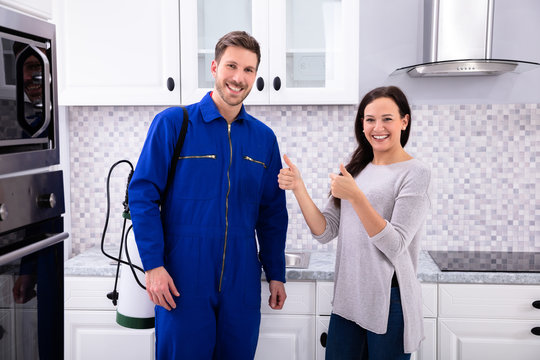 Smiling Woman Showing Thumbs Up Sign With Pest Control Worker