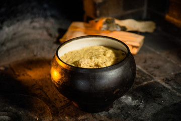 porridge in a cauldron on the background of the oven