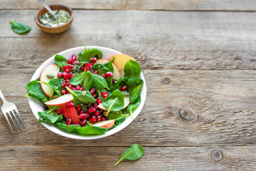 Spinach, apple salad with pomegranate seeds