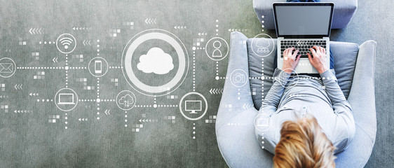 Cloud computing with man using a laptop in a modern gray chair