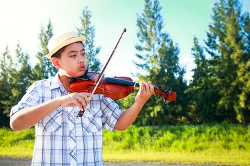Fototapeta premium Boy playing violin outside classroom.