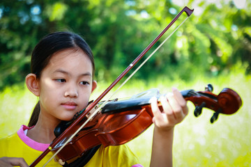 Asian girl standing with violin smiles happy