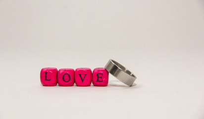 Ring and cube alphabet with love word isolated on white background