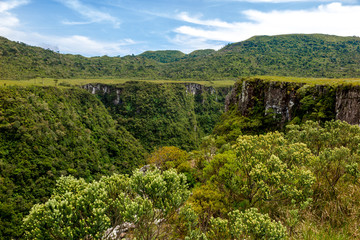Fototapeta na wymiar Walls of the Espraiado Canyon, with lots of vegetation, blue sky with clouds, city of Grão Para, Santa Catarina, Brazil