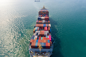 Aerial view. Container ship in pier with crane bridge carries out export and import business in the open sea. Logistics and transportation