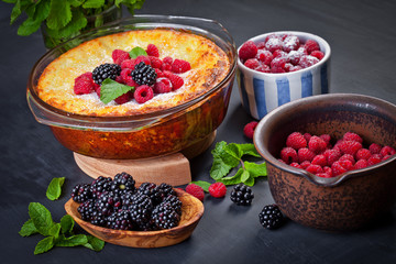 Curd cheese cake with raspberries, blackberries and mint leaves. Sugar-free. Healthy diet. Black background