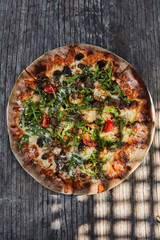 Pizza with truffle, rocket, cherry tomatos and italian cheeses