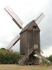 Fototapeta na wymiar Old windmill made of wood in the field