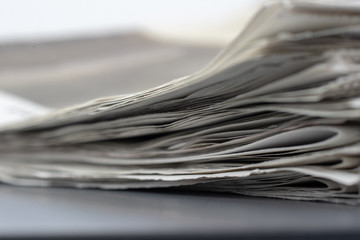 Macro shot of a stack of newspapers. The newspapers are folded