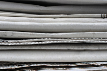 Macro shot of a stack of newspapers. The newspapers are folded