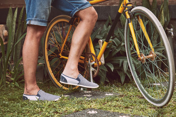 Naklejka premium Attractive man standing with old bicycle.