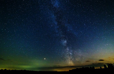 Fototapeta premium Starry sky and the milky way over the field.