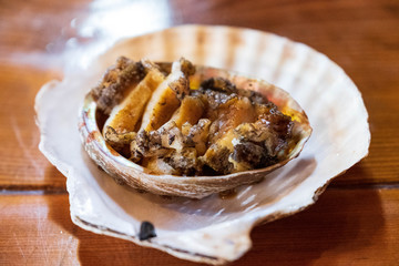 Abalone sea food, fresh abalone cut into small pieces in the shell at fish market in Japan