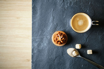 Top view of freshly brewed coffee on slate with sugar mini pastry with text space