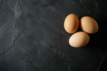 Top view of chicken eggs on slate with text space
