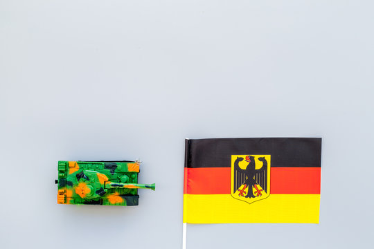 War, military threat, military power concept. Germany. Tanks toy near German flag on grey background top view space for text