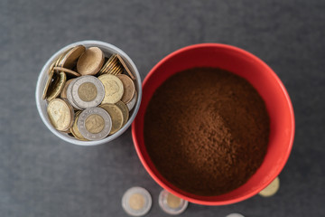 Styrofoam cup full of coins with red bowl of instant coffee