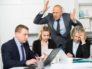 Group of sad frustrated employees receiving rebuke, suffering from bad attitude of shouting...