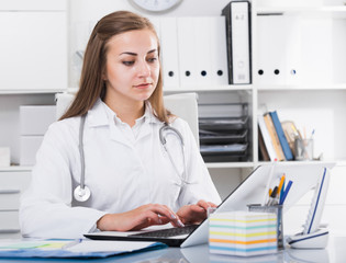 Obraz na płótnie Canvas Doctor female in uniform is working behind laptop