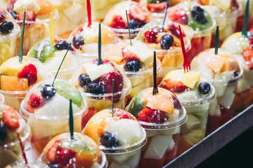 Fruits tranchés dans des gobelets en plastique sur un stand au marché de la Boqueria à Barcelone
