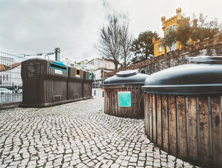 Wide-angle view of three huge plastic containers for separate garbage collection and two compost...