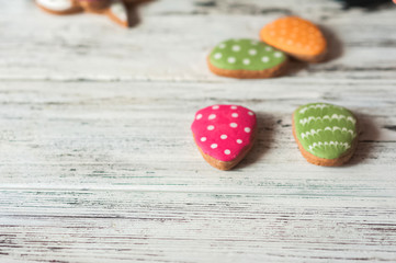 Painted ginger Easter gingerbread, colorful eggs on a wooden textural white background close-up and copy space. Easter greeting card concept