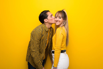 Young couple on vibrant yellow background.