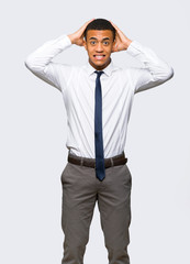 Young afro american businessman takes hands on head because has migraine on isolated background