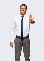Young afro american businessman happy and counting four with fingers on isolated background