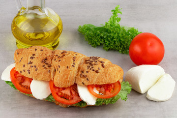 Croissant sandwich with lettuce mozzarella and tomato. Healthy snack