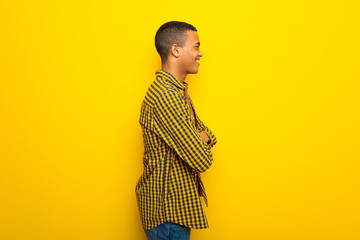 Young afro american man on yellow background in lateral position