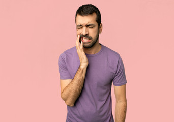 Handsome man with toothache on isolated pink background