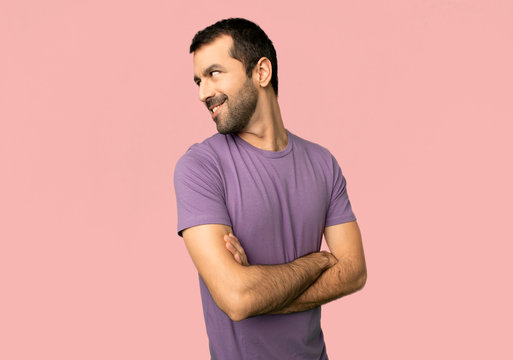 Handsome Man Looking Over The Shoulder With A Smile On Isolated Pink Background