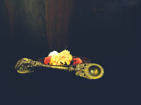 copper spoon for worshiping with yellow and orange flowers