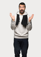 Sport man with surprise and shocked facial expression over isolated grey background