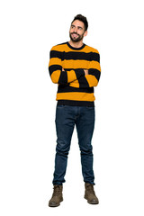 Fototapeta premium Full-length shot of Handsome man with striped sweater looking up while smiling on isolated white background
