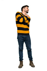 Full-length shot of Handsome man with striped sweater suffering from pain in shoulder for having made an effort on isolated white background