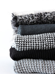 Stack of various sweaters isolated on white background.A stack of knitted sweaters ,the concept of warmth and comfort, hobby , background,closeup