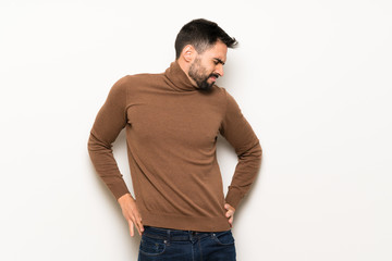 Fototapeta premium Handsome man over white wall suffering from backache for having made an effort
