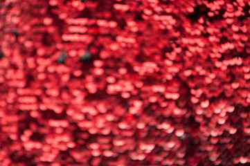 Obraz na płótnie Canvas Red glittery defocused background with blinking details.