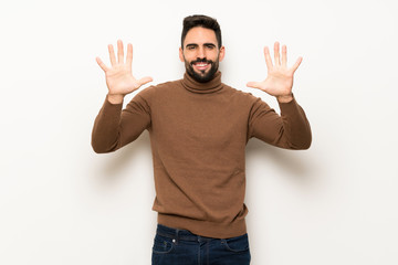 Fototapeta premium Handsome man over white wall counting ten with fingers