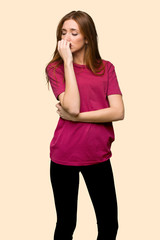 Young redhead girl having doubts on isolated yellow background