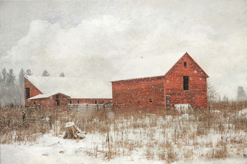 Textured photograph of an old red barn with a snow covered roof on a snowy winter day © Janice